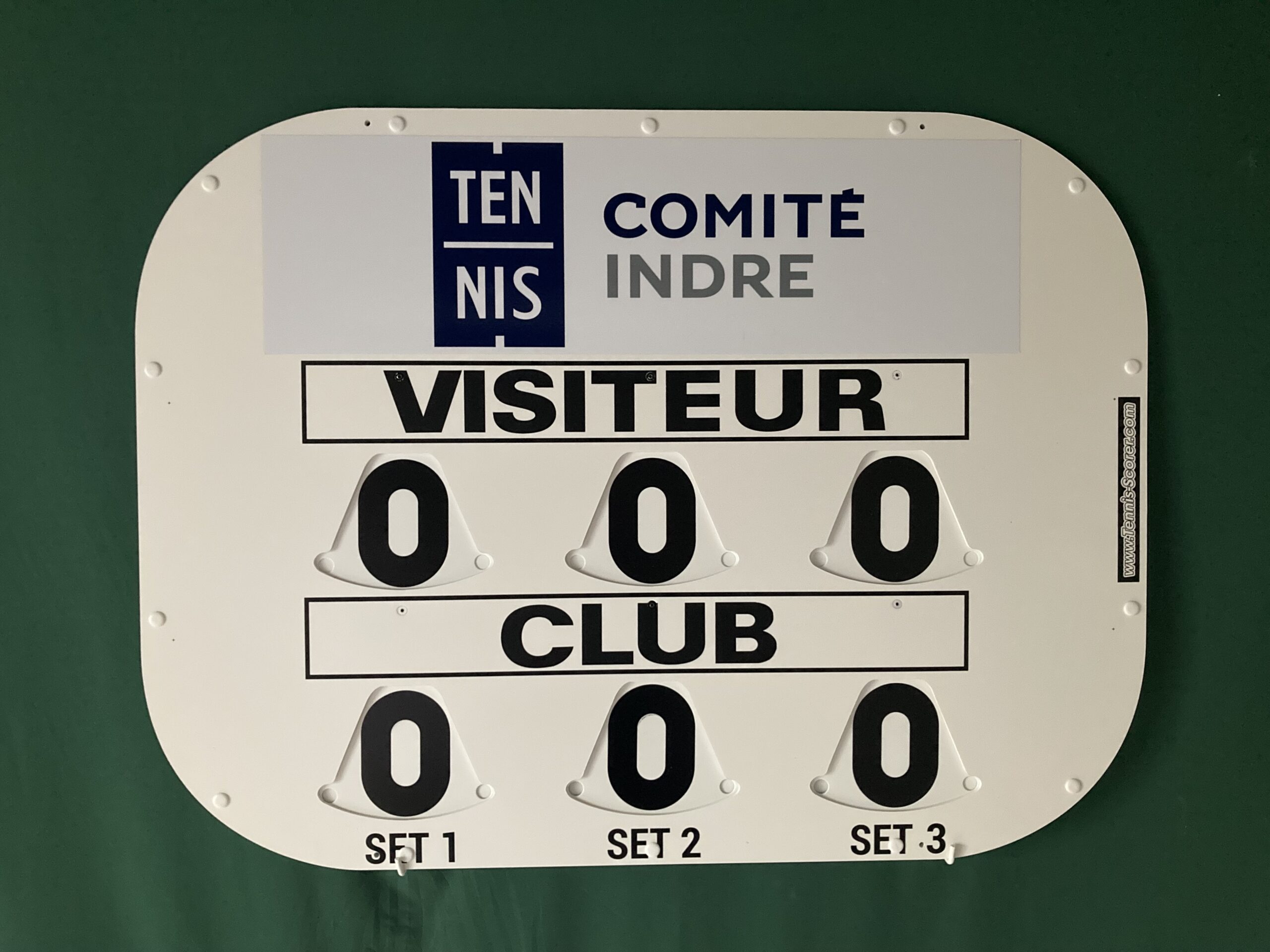 Anzeige einer Scoreboard-Plakette mit dem Aufdruck TENNIS COMITÉ INDRE VISITEUR CLUB und Nullzahlen.