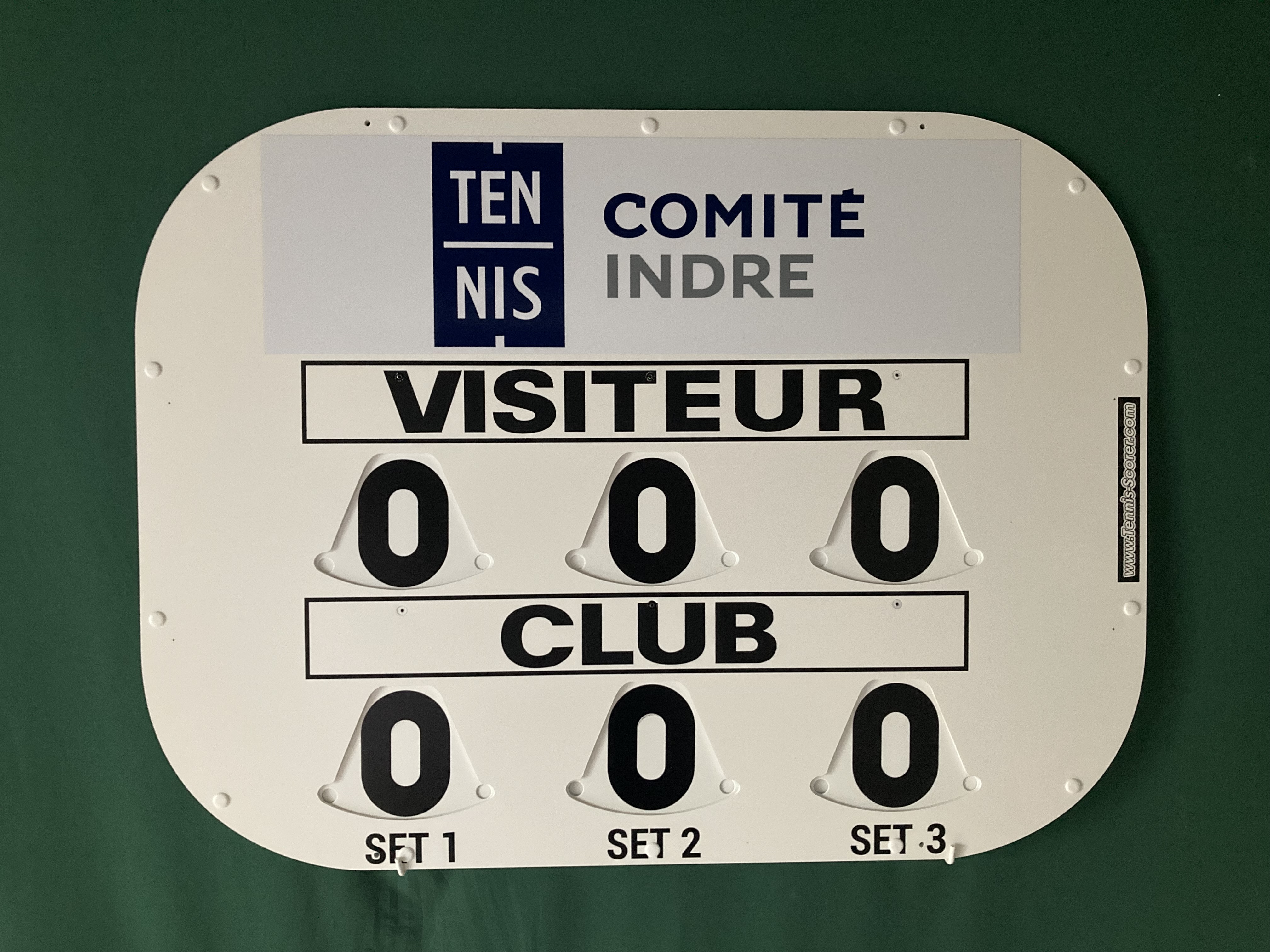 Anzeige einer Scoreboard-Plakette mit dem Aufdruck TENNIS COMITÉ INDRE VISITEUR CLUB und Nullzahlen.